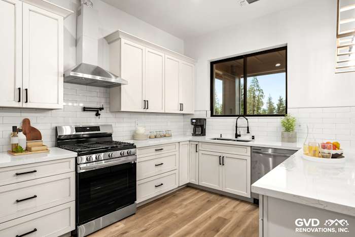 Modern kitchen featuring white shaker cabinets, black appliances, quartz countertop, and large window for natural light