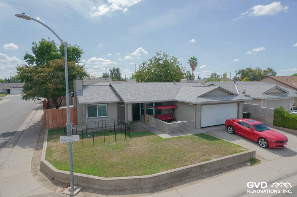 Home exterior featuring James Hardie Monterey Taupe siding and Milgard windows in North Highlands, CA. Red car parked