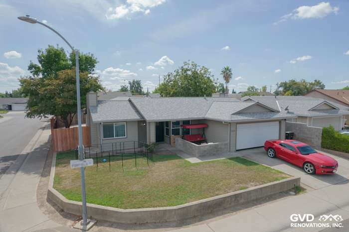 Home exterior featuring James Hardie Monterey Taupe siding and Milgard windows in North Highlands, CA. Red car parked