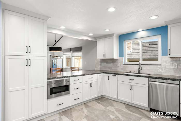 Modern kitchen remodel in Fair Oaks featuring white shaker cabinets, stainless steel appliances, and a blue accent wall