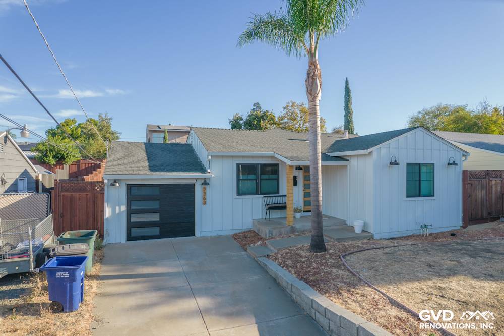 Modern home exterior featuring Arctic White vertical siding and trim in Concord, CA, with dark garage door and landscaping