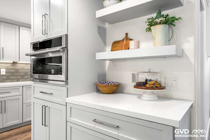 Modern kitchen corner showcasing gray cabinetry, quartz countertop, and open shelving with decorative items in Rocklin