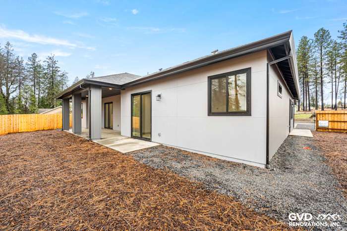 New construction home exterior in Paradise, CA featuring James Hardie siding, Milgard black windows, and landscaped yard