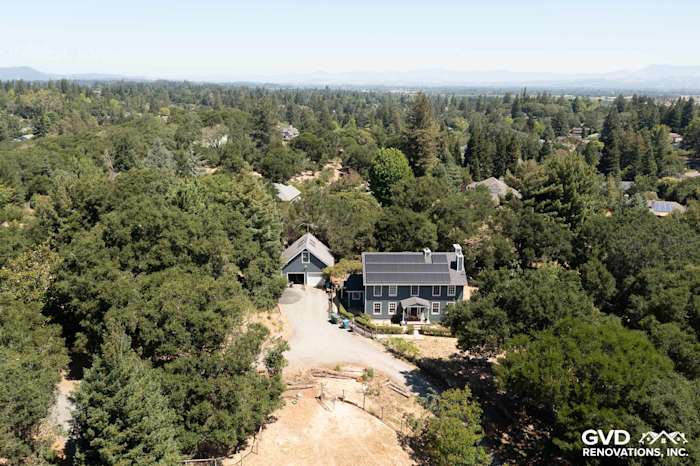 Aerial view of a home featuring Evening Blue James Hardie lap siding and Arctic White trim in a lush, green landscape
