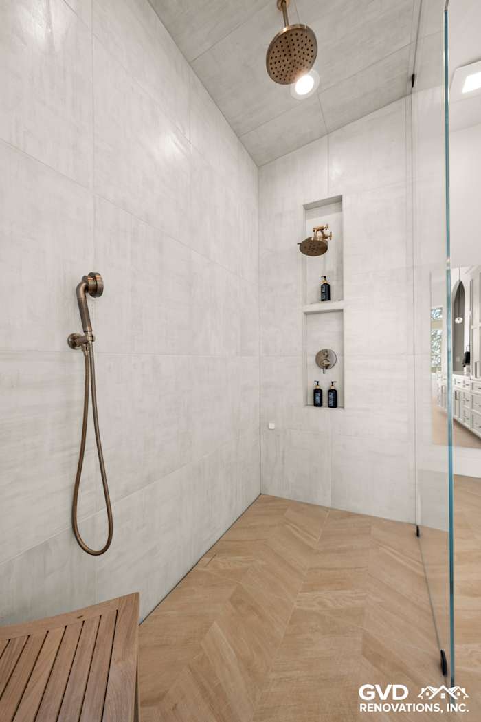 Luxurious zero-threshold steam shower with custom tile, rain showerhead, and recessed shelves in El Dorado Hills bathroom
