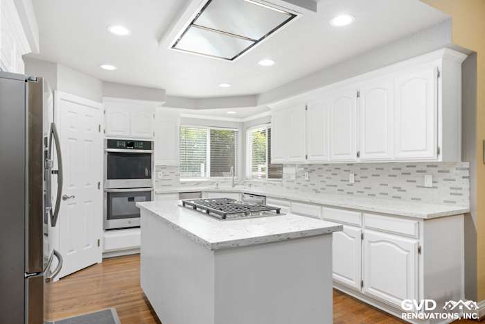 Bright Fair Oaks kitchen featuring white cabinets, granite countertops, and stainless steel appliances