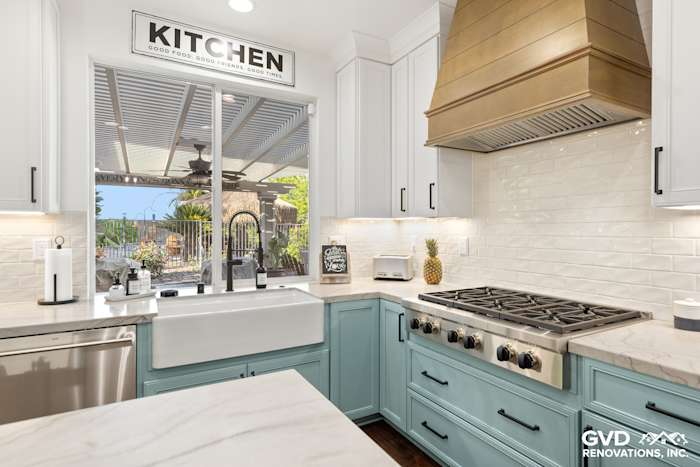 Modern kitchen remodel in Roseville featuring blue cabinetry, quartzite countertops, and a farmhouse sink