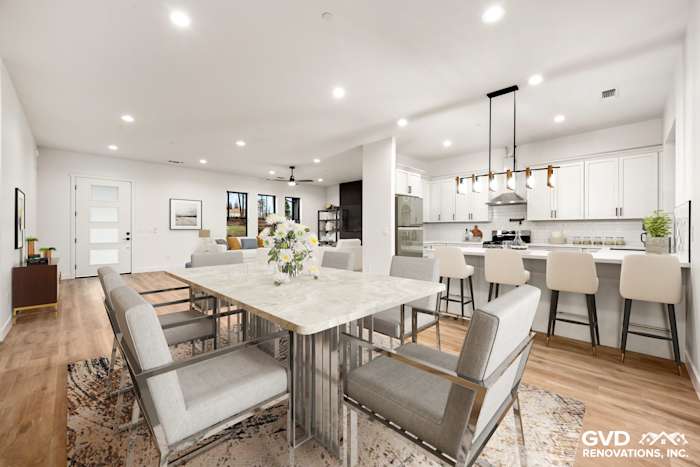 Spacious open-concept living area in new construction, featuring a modern dining table, elegant lighting, and large windows