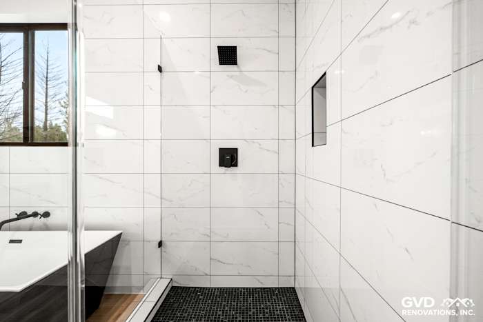 Sleek bathroom featuring a modern black bathtub, black tile flooring, and white marble walls in Paradise, CA