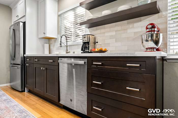 Modern kitchen with dark wood cabinets, stainless steel dishwasher, white quartz countertop, and open shelving
