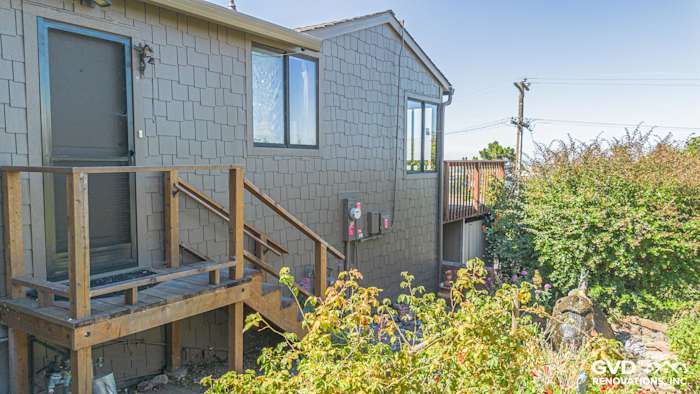Home exterior in Vallejo featuring James Hardie Shake siding, custom-painted gray, and wooden deck entrance