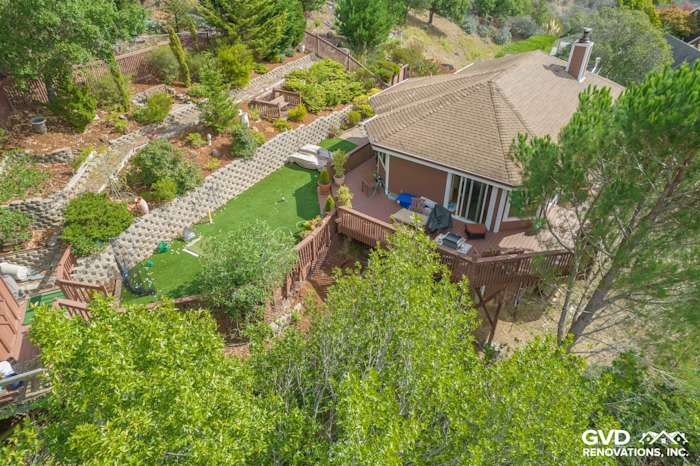 Home exterior in Mill Valley with a landscaped backyard, wooden deck, and surrounding greenery