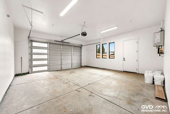 Spacious garage with polished concrete floor, natural light from large windows, and modern overhead door