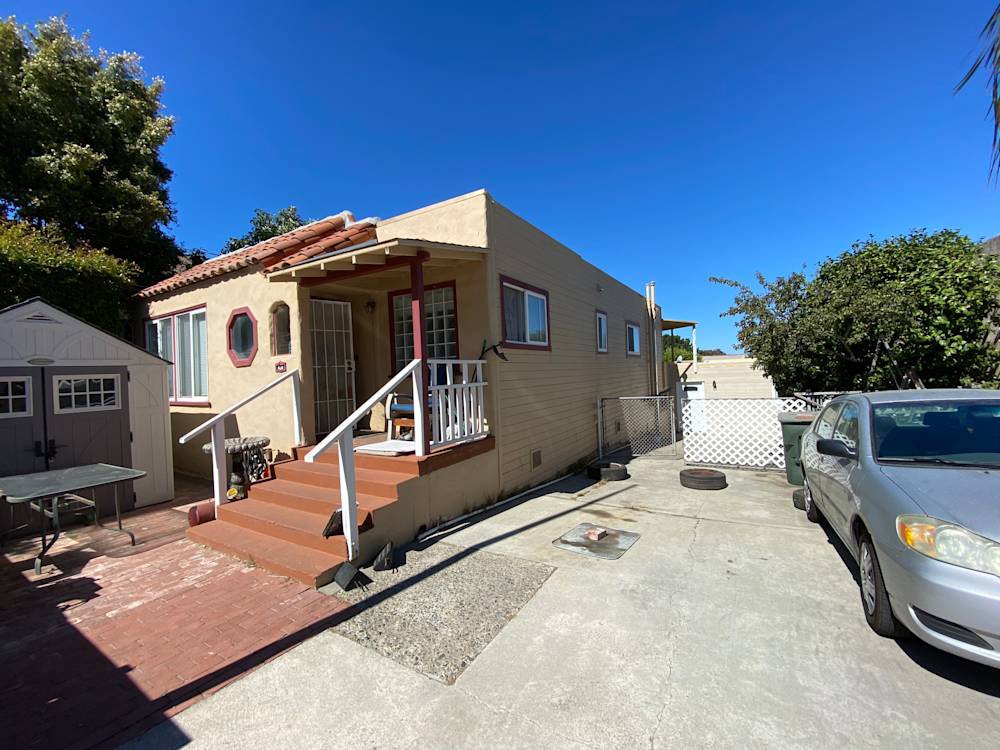 Single-story home with beige exterior, red tiled roof, and concrete driveway in Sacramento