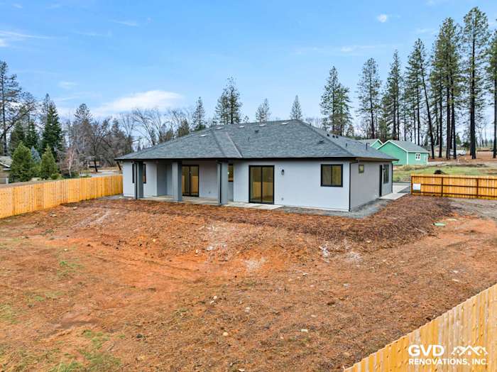 New construction home in Paradise, CA, featuring James Hardie siding, black Milgard windows, and a clear sky