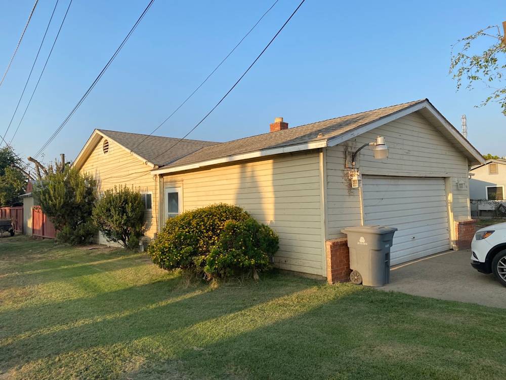 Single-story home in Sacramento with beige siding, green lawn, and driveway