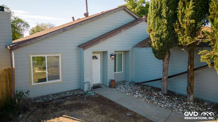 Recently installed James Hardie Lap Siding in light blue on a Sacramento home's exterior with a landscaped walkway