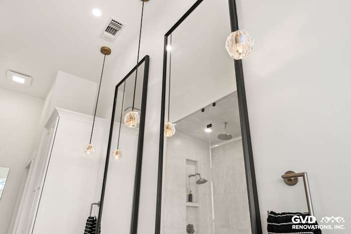 Luxurious bathroom featuring sleek black-framed mirrors, pendant lighting, and modern tile accents in El Dorado Hills