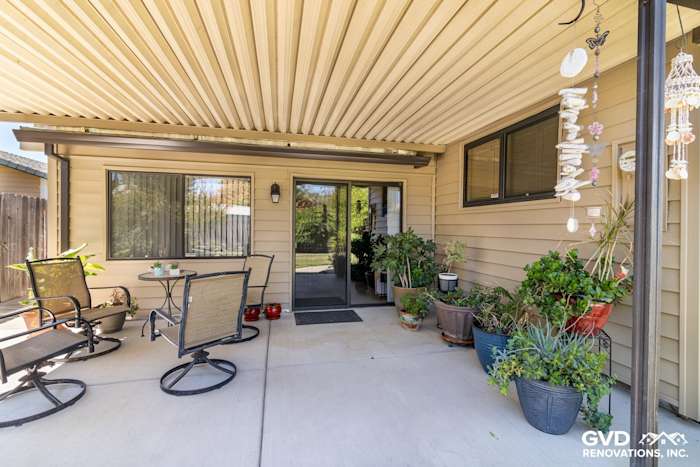 Updated entryway featuring Alside Prodigy vinyl siding, potted plants, and outdoor seating in Rio Linda, CA