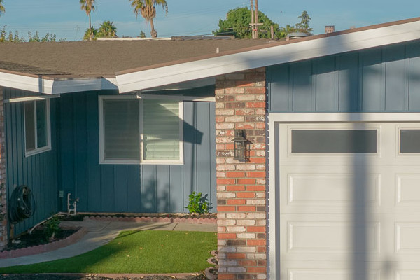 Home exterior featuring Prodigy Vinyl Siding in blue with brick accents and landscaped front yard in Antioch, CA