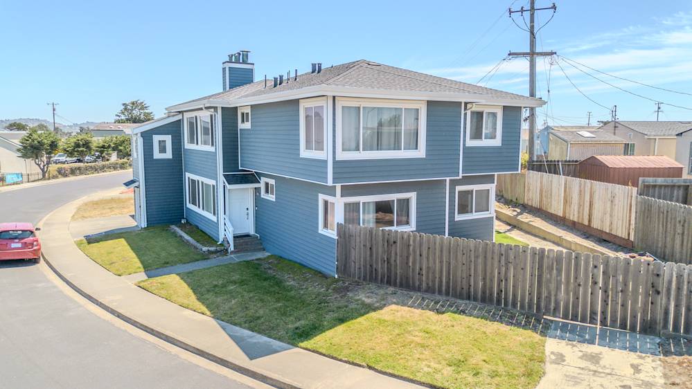 Modern two-story home with fresh blue siding and updated windows, enhanced curb appeal