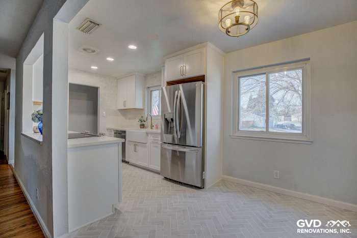 Bright kitchen with white cabinets, stainless steel appliances, and herringbone tile flooring in Fair Oaks, CA
