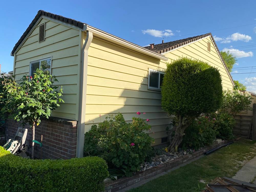 Exterior view of a home in Sacramento with yellow siding and lush greenery