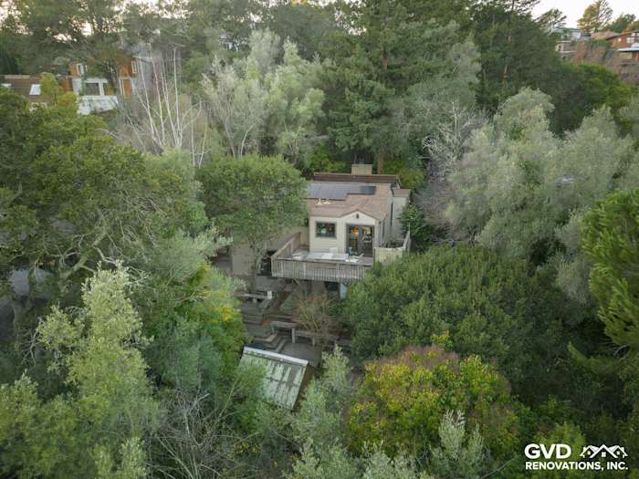 Oakland home with Khaki Brown James Hardie siding and Marvin windows surrounded by lush greenery and trees