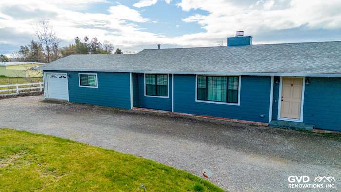 Sonoma home exterior featuring new James Hardie Evening Blue siding and Arctic White trim, with front door and windows
