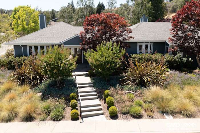 Home exterior featuring James Hardie CedarMill lap siding in Evening Blue, with Arctic White trim and landscaped pathway