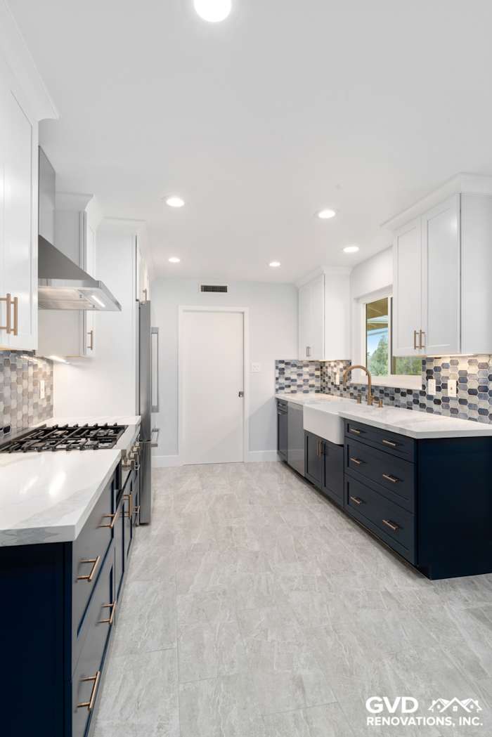 Modern kitchen remodel featuring navy cabinets, white quartz countertops, and decorative backsplash in Sacramento