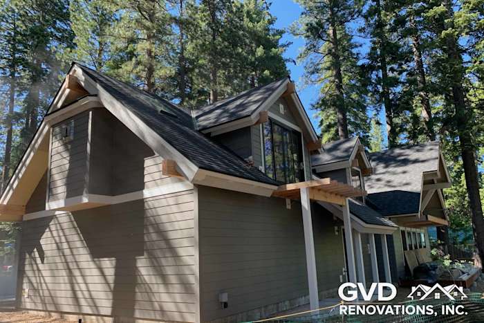 Contemporary home exterior featuring James Hardie siding and trim, surrounded by tall pine trees in Tahoe City