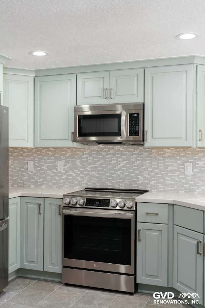 Modern kitchen with light blue cabinets, stainless steel appliances, and patterned backsplash in Cameron Park