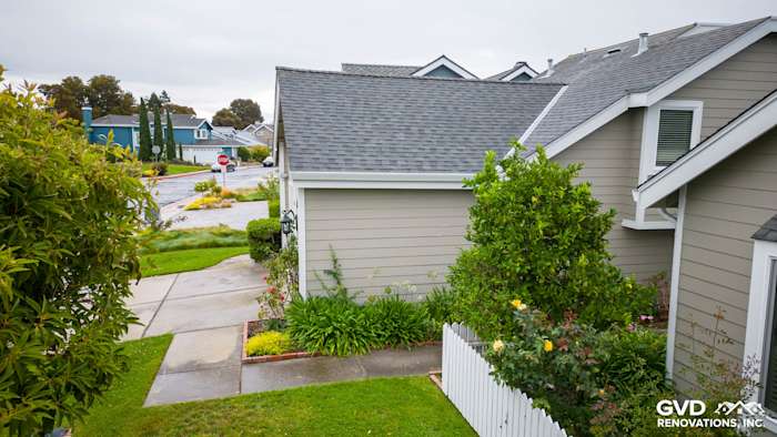 Foster City home with Monterey Taupe James Hardie siding, white trim, and lush landscaping in front