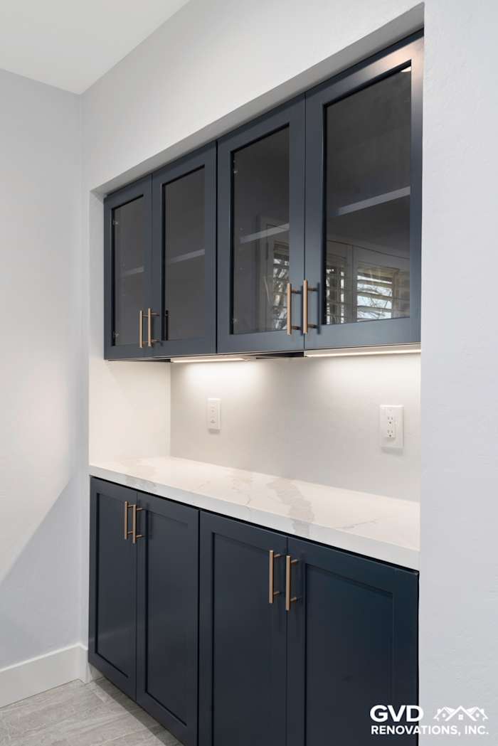Modern kitchen remodel featuring navy blue cabinets, quartz countertop, and sleek brass hardware in Sacramento
