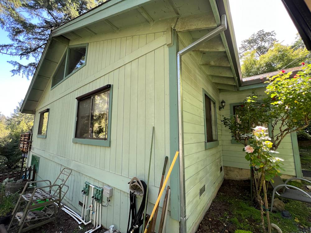 Light green exterior siding with windows, nearby garden and tools, located in Sacramento area