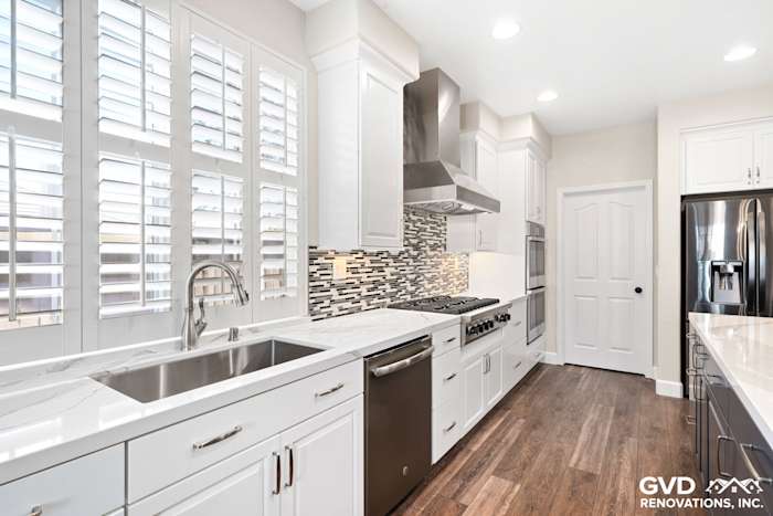 Modern kitchen featuring white cabinets, sleek stainless steel appliances, marble countertops, and a stylish tile backsplash