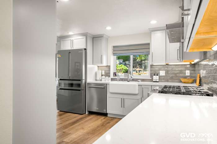 Modern kitchen in Rocklin featuring gray cabinetry, quartz countertops, stainless steel appliances, and ample natural light