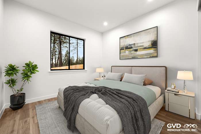 Bright bedroom in new construction featuring large windows, modern furnishings, and warm wood flooring in Paradise, CA