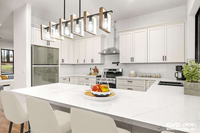 Bright kitchen with white cabinetry, quartz countertops, modern pendant lights, and stainless steel appliances in Paradise