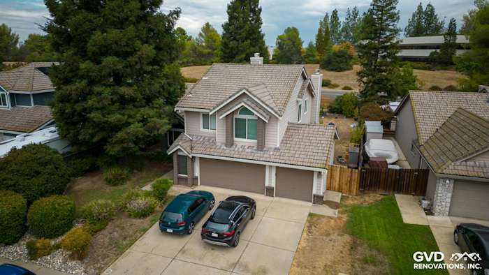 Home exterior featuring newly installed Craneboard vinyl siding and windows, charming roofline, and landscaped yard