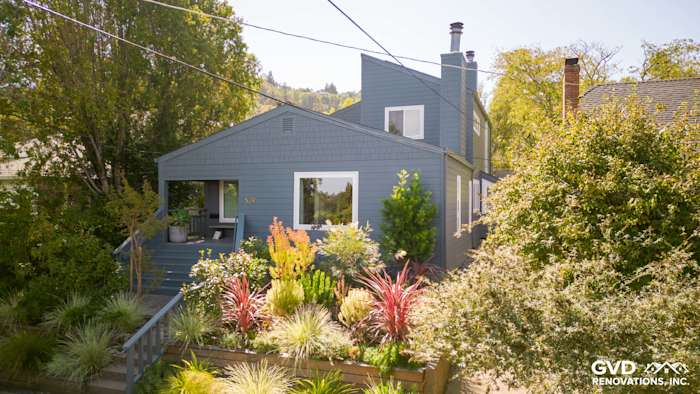 Home exterior featuring James Hardie Cedarmill siding in Evening Blue with Arctic White trim and lush landscaping