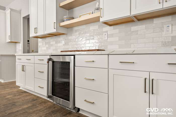 Modern kitchen featuring white Diamond cabinets, floating shelves, MSI countertops, and a stylish backsplash in Roseville