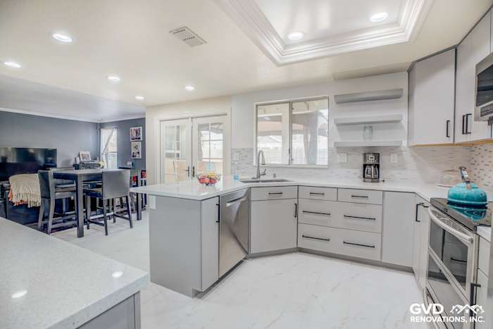 Modern kitchen remodel with gray cabinets, quartz countertops, and white subway tile backsplash in Sacramento