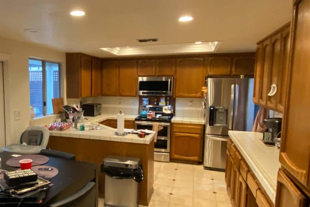 Outdated kitchen with dark wood cabinets, white countertops, and tile flooring in Sacramento home