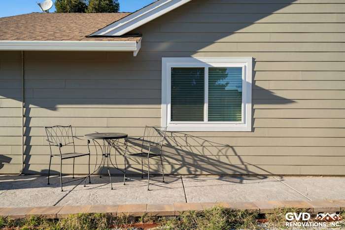 Monterey Taupe HardiePlank siding with Arctic White trim, featuring a patio table and chairs in Folsom, CA