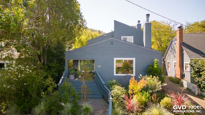 Corte Madera home exterior featuring James Hardie Evening Blue siding and Arctic White trim with lush landscaping
