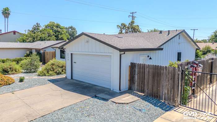 Exterior view of a home in Rancho Cordova with James Hardie Board & Batten Siding in Arctic White and a new garage door