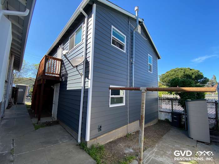 Side view of a home featuring newly installed dark gray CraneBoard vinyl siding and Anlin windows in Rio Vista