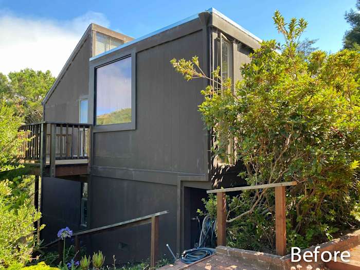 Dark James Hardie siding on a Mill Valley home, surrounded by greenery, before remodeling